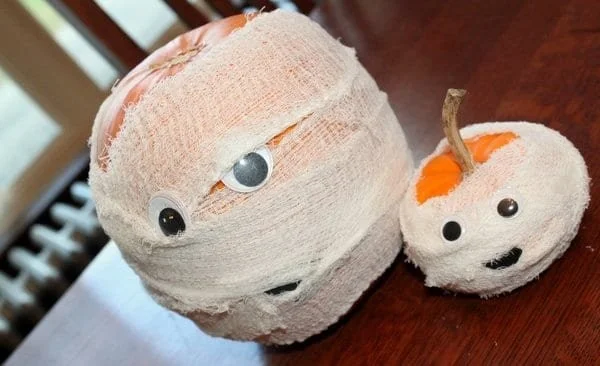 A family of playful Pumpkin Mummies decorated for Halloween celebrations.