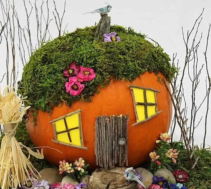 Charming Pumpkin Fairy House nestled in a whimsical garden setting.